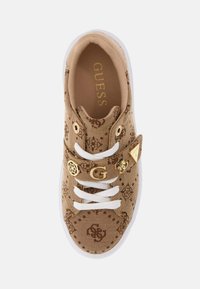 Adidașs textiles bej cu accente din metal auriu, având un design cu model, șireturi albe și talpă din cauciuc. Logo-ul brandului este vizibil în interior.