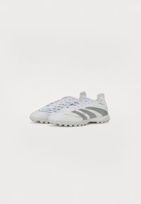 Weiße Sportschuhe mit einer glatten Oberseite, blauen und grauen Akzenten, einem Schnürdesign und einer strukturierten Sohle für besseren Grip.