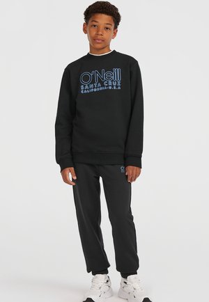 Svart sweatshirt med blå grafisk logotyp, matchad med svarta joggingbyxor och vita sneakers. Mjuk tyg med ribbade muddar och anklar.