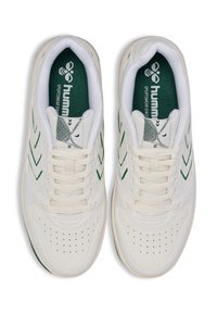 Vita idrottsskor i vitt med gröna accenter, inklusive zickzackränder och en texturerad tåbox. Har snörning, vadderad krage och logotyp på tungan.