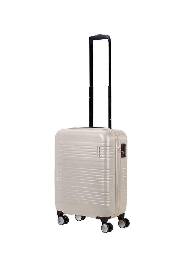 Valise rigide beige clair avec quatre roues pivotantes et une poignée télescopique noire extensible sur fond blanc.