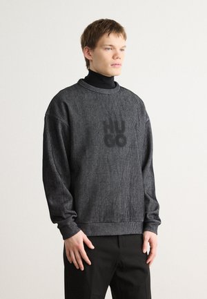 Dark gray pullover sweater with a ribbed texture and dropped shoulders. Features a subtle logo, crew neckline, and long sleeves.