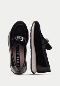 Svarta loafers med ovandel i mocka, en läderrem med krokodilprägling, gummisula och silverfärgad spänne. Bekväm design med texturerade detaljer.