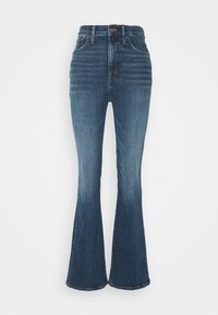 Högmidjade utsvängda jeans gjorda av mörkblå denim. Har en knäppning, subtil blekning och en åtsittande passform över låren.