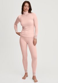 Long-sleeve, ribbed thermal top and matching leggings in soft pink, featuring lace accents at the cuffs and ankle hems.