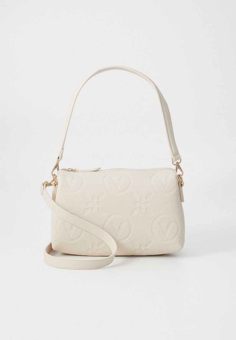 Cream-colored handbag with a textured surface featuring embossed floral and circular designs, adjustable strap, and gold-tone hardware.