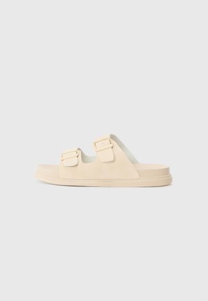 Sandalettes beiges avec deux brides réglables, en suédine lisse, et une semelle épaisse pour le confort. Design minimaliste, bout ouvert.