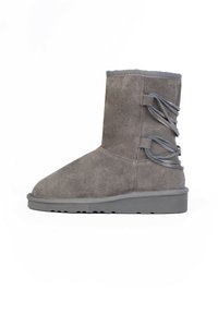 Stivaletto in suede grigio con punta rotonda, suola in gomma piatta e decorativi dettagli in pizzo incrociato sul lato esterno.