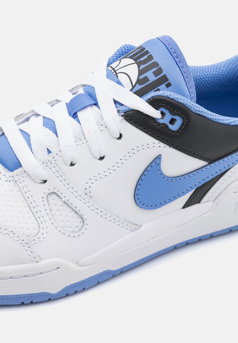 Baskets blanches avec des accents bleu et noir, présentant un dessus en cuir lisse, une texture perforée, un col rembourré et une semelle contrastante.