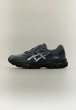 Čierna bežecká obuv Asics so sivo-striebristými reflexnými pruhmi a čiernou polstrovanou podrážkou, zobrazená z boku na neutrálnom pozadí.