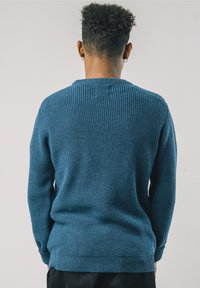 Texturierter Pullover mit langen Ärmeln in einem satten Blauton, mit einem Rippenmuster entlang des Ausschnitts, der Bündchen und des Saums.