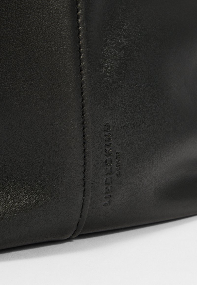 Schwarze Lederhandtasche mit glatter Textur, mit gestepptem Naht und eingeprägtem Markennamen "LIEBESKIND" auf der Seite.