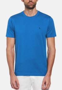 Blauwe katoenen t-shirt met een ronde halslijn en korte mouwen. Heeft een klein geborduurd pinguïnlogo in marineblauw op de linkerkant van de borst.