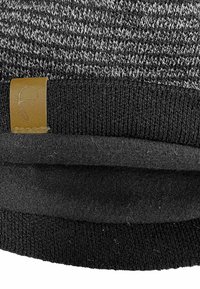 Knitted beanie in gray and black with a folded brim. Features a brown leather tag with a logo. Soft texture and snug design.