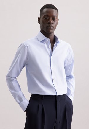 Lichtblauw overhemd met fijne witte strepen, lange mouwen en een spread collar, gecombineerd met donker op maat gemaakte broeken.