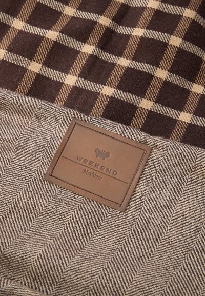 Pruunruuduline kangas beežide aktsentidega, mis muutub kalasabamustriks. Sisaldab pruuni nahast sildi, millel on kirjas "WEEKEND MaxMara".