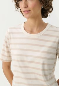 Short-sleeved, cream t-shirt with light beige horizontal stripes. Features a round neck and soft cotton texture.