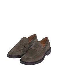 Green suede loafers with a low heel, featuring a stitched moccasin toe design and a decorative strap across the upper. Black rubber sole.