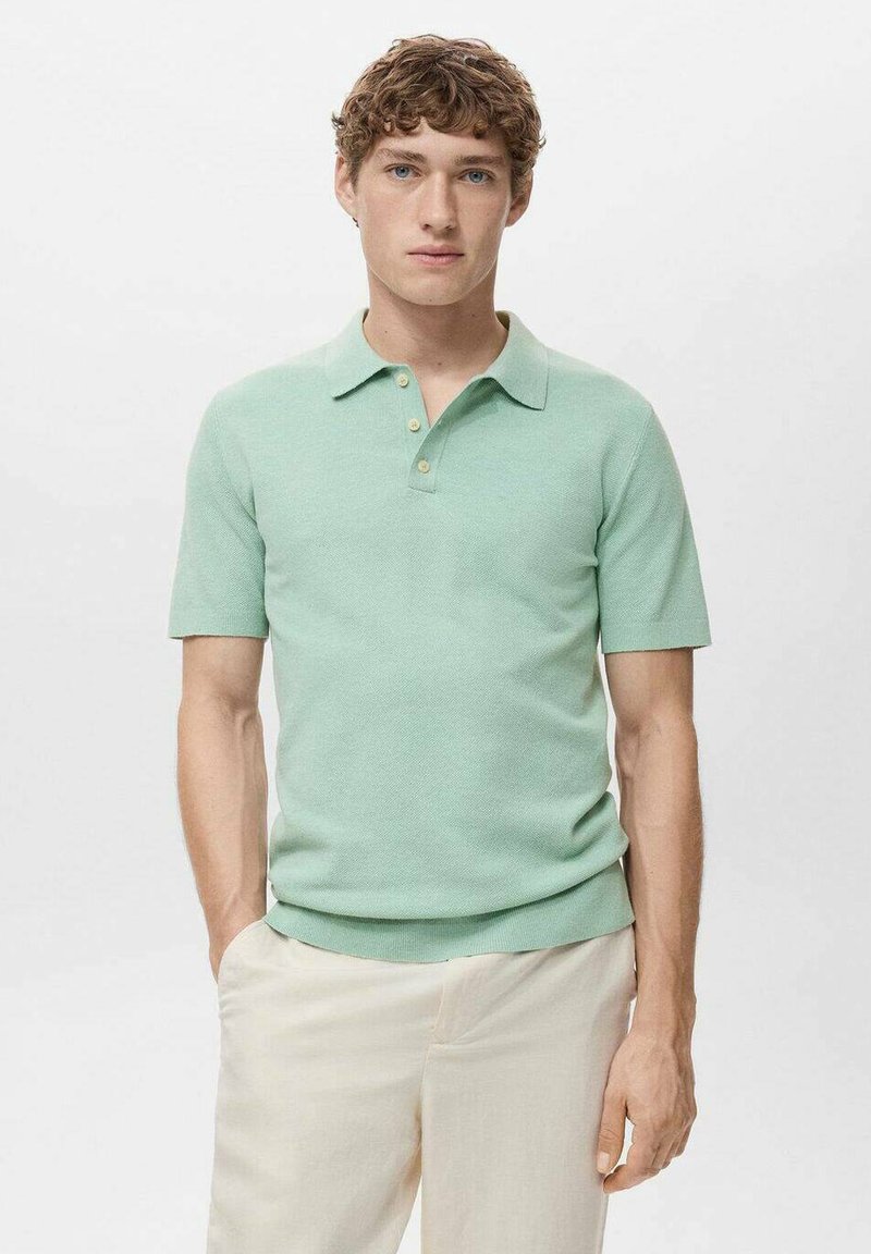 Polo a maniche corte di colore verde menta, realizzato in tessuto a maglia con una texture strutturata, con colletto classico e tre bottoni chiari.