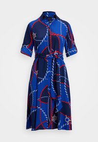 Námořnické šaty s designem na knoflíky, včetně červeného a modrého provázkového vzoru a akcentů lodního kormidla. Obsahují pásový opasek a manžety na ohrnutí.