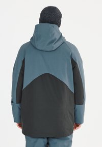 Wasserdichte Jacke mit einem Design in Blau- und Schwarzfarbblock. Verfügt über eine Kapuze, lange Ärmel und einen strukturierten Stoff.