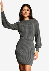 Rochie tricotată gri, cu o textură ribbed, model de răchită pe corset și mâneci bufante cu manșete ribbed.