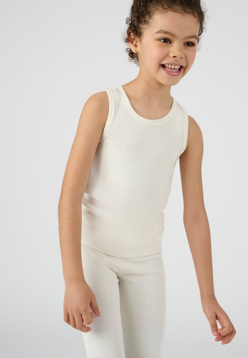 Top in colore crema senza maniche e leggings coordinati realizzati in materiale morbido ed elastico. Design senza maniche con scollatura rotonda e silhouette aderente.