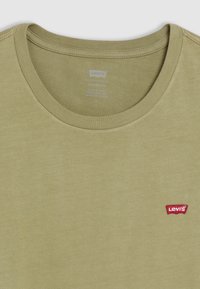 Alyvmedžio žalia medvilninė marškinėliai su apvalia iškirpte, trumpomis rankovėmis ir raudonu Levi's logotipo ženkliuku kairiajame krūtinės srityje.