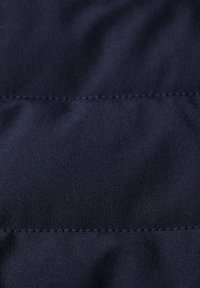 Marinblått tyg med en slät textur och subtil lyster, med horisontella sömmar. Lättviktig och hållbar material.