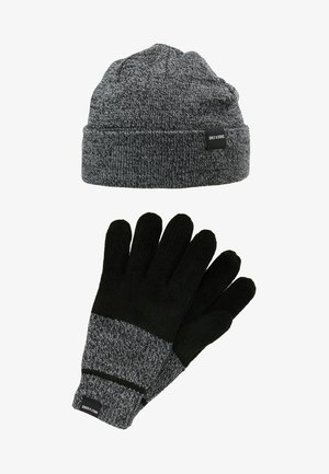 Bonnet en tricot gris avec une bordure repliée et une étiquette de logo, accompagné de gants noirs avec un poignet en tricot gris et une paume texturée pour une meilleure prise.