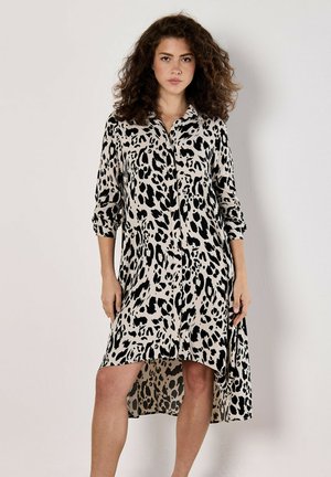 Kjole i leopardprint i beige og sort. Lange ærmer, knaplukning foran, høj-lav kant med bølgende stofstruktur.