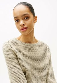 Hellbeige gestrickter Pullover mit U-Boot-Ausschnitt und strukturiertem Muster, mit gerippten Bündchen und Saum. Glattes, weiches Material.