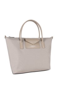 Sac fourre-tout beige en tissu texturé avec des accents en cuir lisse, doté de deux poignées, d'une fermeture éclair sur le dessus et d'une poche à rabat triangulaire.