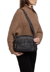 Borsa a tracolla nera con motivo logo, chiusura con zip e tracolla regolabile. Realizzata in materiale resistente con dettagli in metallo color oro.