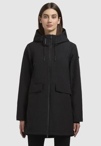 Black waterproof jacket with a hood, featuring a zipper front, two front pockets, and adjustable drawstrings. Smooth texture, knee-length design.
