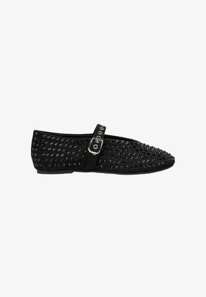 Scarpe flat nere con punta a cono, ricoperte di borchie lucide, dotate di una cinghia con fibbia metallica sul lato e una texture morbida.