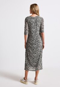 Langes, enges Kleid aus transparentem grauen Stoff mit einem schwarzen abstrakten Muster. Verfügt über Dreiviertelärmel und ein ausgeschnittenes Rückendesign.