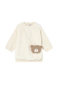 Top in peluche color crema con texture a coste, maniche lunghe e una borsa a tracolla a forma di orsetto in morbido marrone con un dettaglio bianco sul viso.