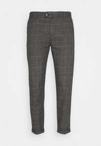 Pantalones de cuadros gris ajustados con cierre de botón y dobladillos acampanados, presentados sobre un fondo blanco.