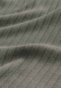 Texturiertes grünes Gewebe mit subtilen horizontalen Streifen. Das Material wirkt weich und gestrickt und zeigt im Licht einen leichten Glanz.
