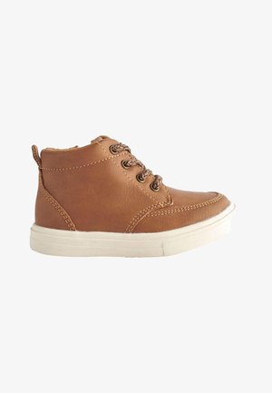 Sneaker montante en cuir marron avec semelle en caoutchouc blanche et lacets marron à motifs, vue de côté extérieur.
