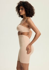Nude seamless shapewear set featuring a fitted bra and high-waisted shaping shorts. Stretchy fabric with smooth texture for comfort.