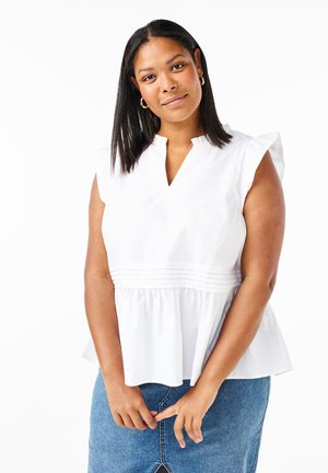 Biele peplum top s výstrihom do V, krátkymi voľnými rukávmi a dekoratívnym smockingom v páse, spárovaný s džínsovou sukňou.