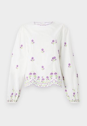 White blouse with long, puffed sleeves. Features purple floral embroidery and a scalloped hem. Textured fabric with a smooth finish.