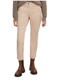 Pantaloni beige chiaro in misto cotone con taglio dritto, tasche anteriori e una tasca laterale a toppa, abbinati a stivali intrecciati marroni.