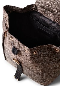 Borsa in tessuto testurizzato nera e beige con chiusura a cordoncino, accessori in oro e fodera interna liscia. Presenta tasche laterali.