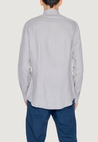 Camicia a maniche lunghe a righe grigio chiaro con colletto a punta e polsini con bottone, caratterizzata da una vestibilità rilassata, realizzata in un tessuto testurizzato.