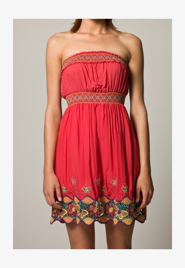 Vestido sin mangas color coral con cinturilla elástica. Presenta vibrantes bordados florales en el dobladillo y un intrincado detalle en hilo multicolor.