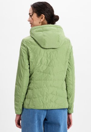 Lichtgroene pufferjack met een capuchon, voorzien van een gewatteerde textuur en diagonale stiksels. De achterkant is lichtjes gecinchd op de taille.