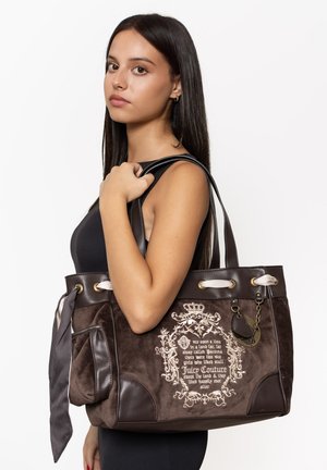 Braune Wildleder-Tote mit Lederakzenten, die über eine cremfarbene Naht und ein dekoratives Muster verfügt. Enthält zwei Träger und ein Kettendetail.